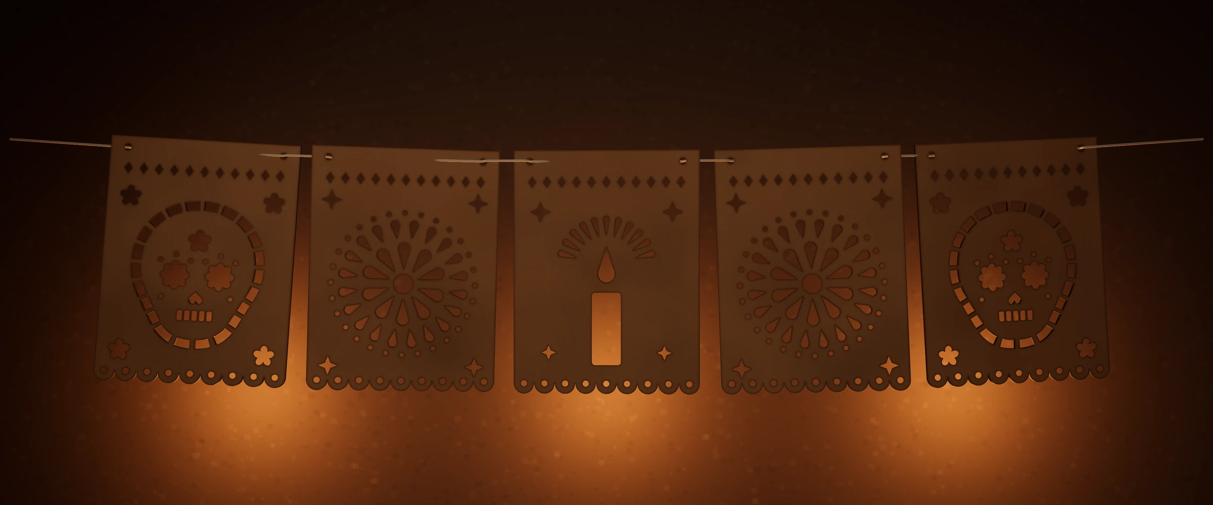 Tira de cinco banderas de papel picado en su versión de MDF —calaveras, cempasúchil y una vela— colgadas de un cordón, con luz de velas detrás.